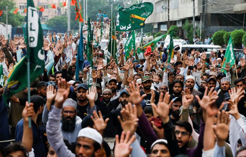 © Reuters. FILE PHOTO: People chant slogans against the satirical French weekly newspaper Charlie Hebdo, which reprinted a cartoon of the Prophet Mohammad, during a protest in Karachi