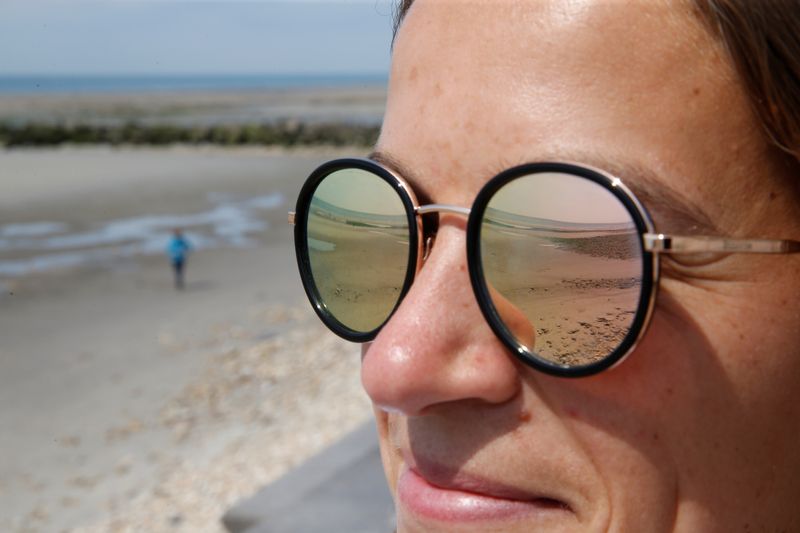 &copy; Reuters. Riflesso di una spiaggia sugli occhiali da sole di una donna, a Wimereux