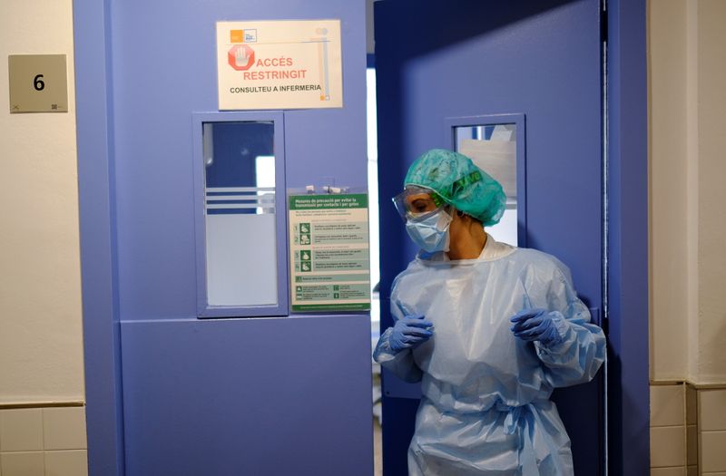 &copy; Reuters. FOTO DE ARCHIVO: Sanitaria se prepara para tratar a un paciente de coronavirus (COVID-19) en un hospital de Barcelona, España