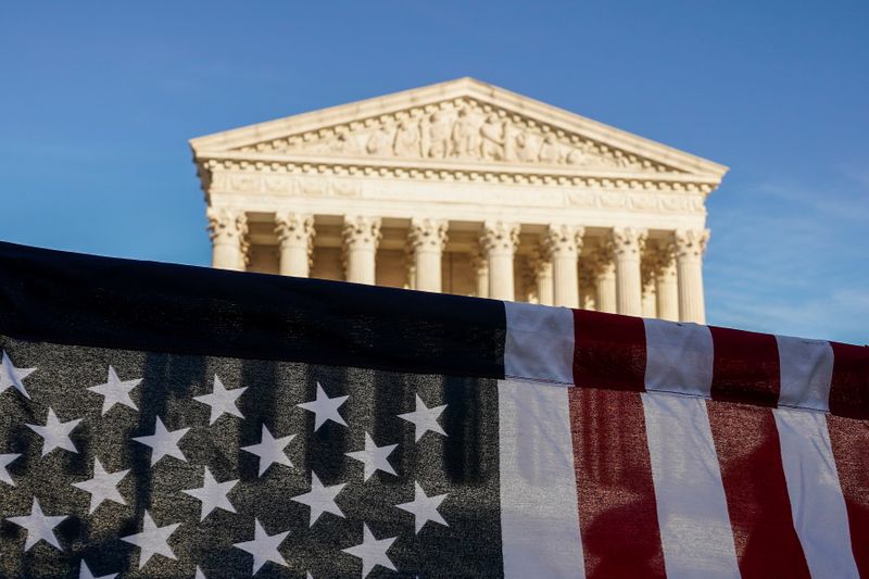 © Reuters. A U.S. flag is seen during a demonstration before a vote on the nomination of Amy Coney Barrett to the Supreme Court in Washington