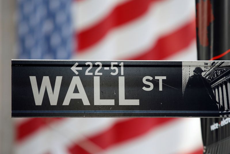 &copy; Reuters. FILE PHOTO: FILE PHOTO: A sign for Wall Street is seen with a giant American flag in the background across from the New York Stock Exchange