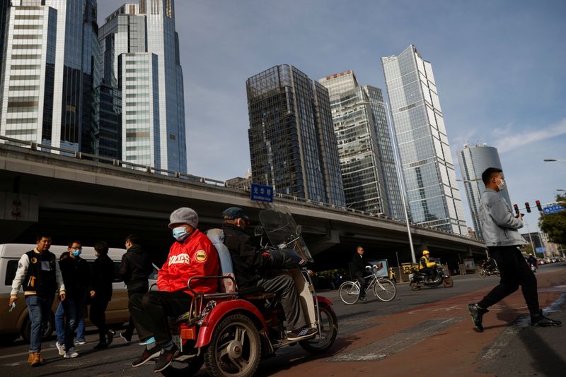 &copy; Reuters. FILE PHOTO:  Elderly people cross a street in a tricycle in the Central Business District (CBD) following an outbreak of the coronavirus disease (COVID-19) in Beijing