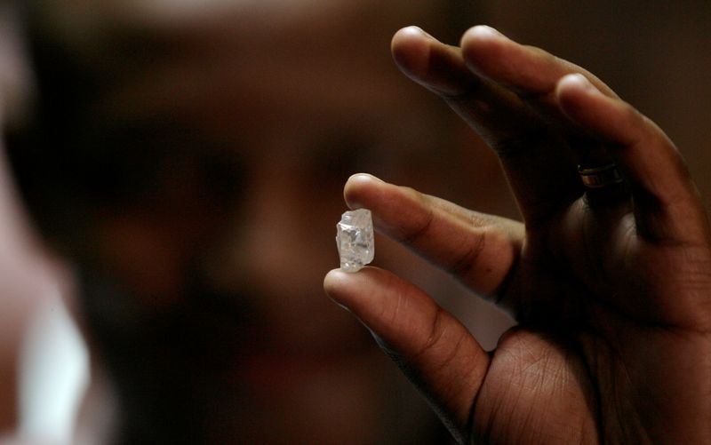 &copy; Reuters. FILE PHOTO: A visitor holds a 17 carat diamond at a Petra Diamonds mine in Cullinan
