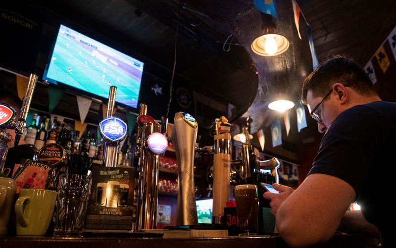 &copy; Reuters. A man uses a smartphone during the broadcast of soccer match of the Belarusian Premier League at a bar in Moscow