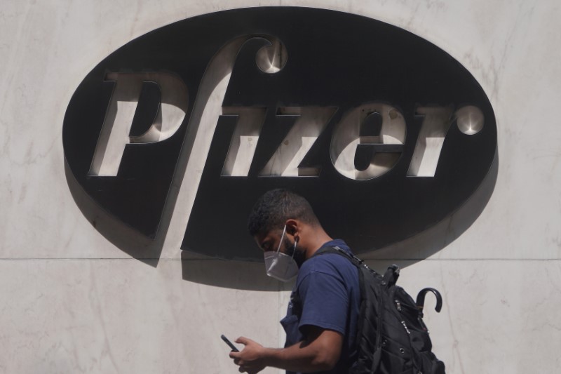 © Reuters. FILE PHOTO: A man walks past a sign outside Pfizer Headquarters in the Manhattan borough of New York City