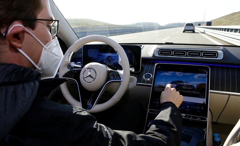© Reuters. An employee demonstrates steering by autonomous driving system in a new Mercedes-Benz S-Class limousine near Immendingen
