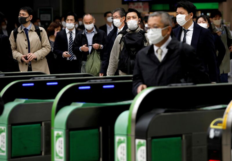 &copy; Reuters. FILE PHOTO: Passengers wearing protective face masks, following an outbreak of the coronavirus disease, are seen at a station after the government announced the state of emergency for the capital following the disease outbreak in Tokyo, Japan