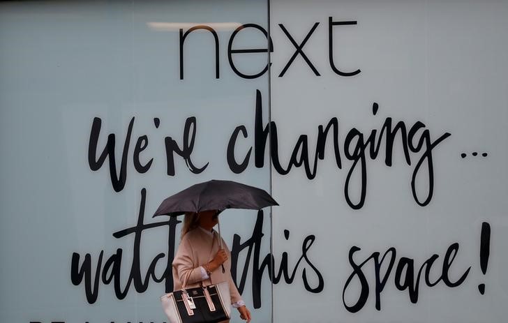 &copy; Reuters. FOTO DE ARCHIVO. Una mujer camina frente a una tienda de Next, en Manchester, Reino Unido.