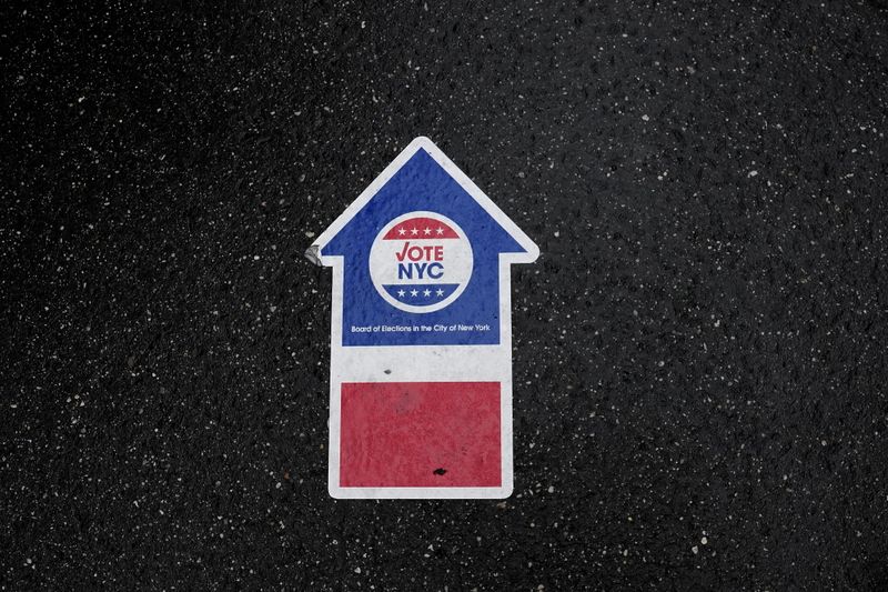 &copy; Reuters. A sign on the ground directs people who line up in the rain to vote at an early site at Madison Square Gardens