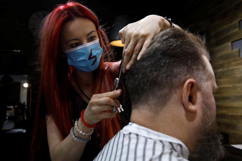 &copy; Reuters. Barber Kinga Rutkowska, 22, cuts hair at a barbershop in Warsaw
