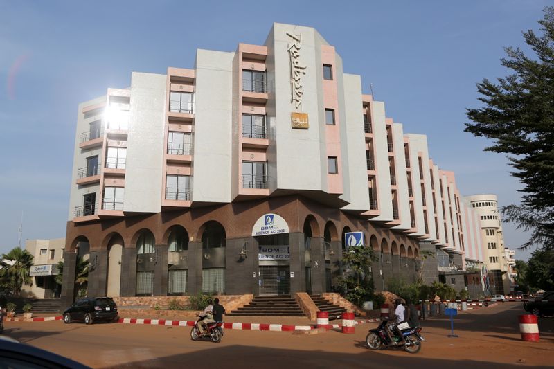 © Reuters. FILE PHOTO: People drive motorcycles past the Radisson Blu hotel in Bamako