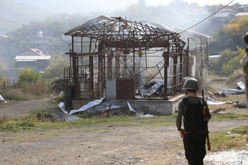 &copy; Reuters. FILE PHOTO: Smoke rises over a damaged building following alleged shelling in Stepanakert