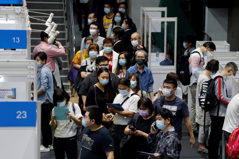 &copy; Reuters. Job seekers wearing face masks fill in forms at the Wan Chai Job Fair, following the coronavirus disease (COVID-19) outbreak, in Hong Kong