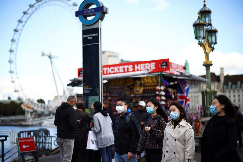 &copy; Reuters. Pessoas usam máscaras de proteção em Londres