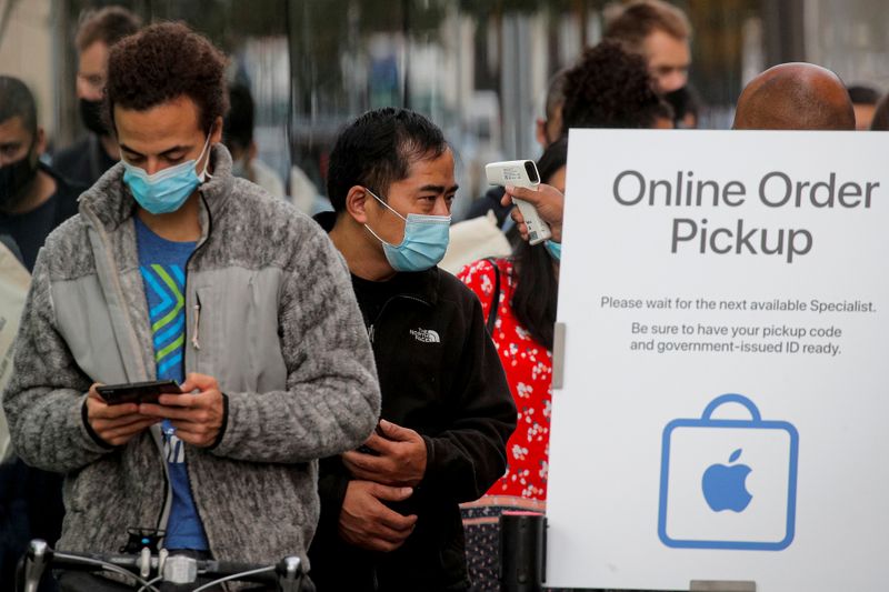 &copy; Reuters. FILE PHOTO: A customer has his temperature taken while in line outside an Apple Store to pick up Apple&apos;s new 5G iPhone 12 in Brooklyn, New York