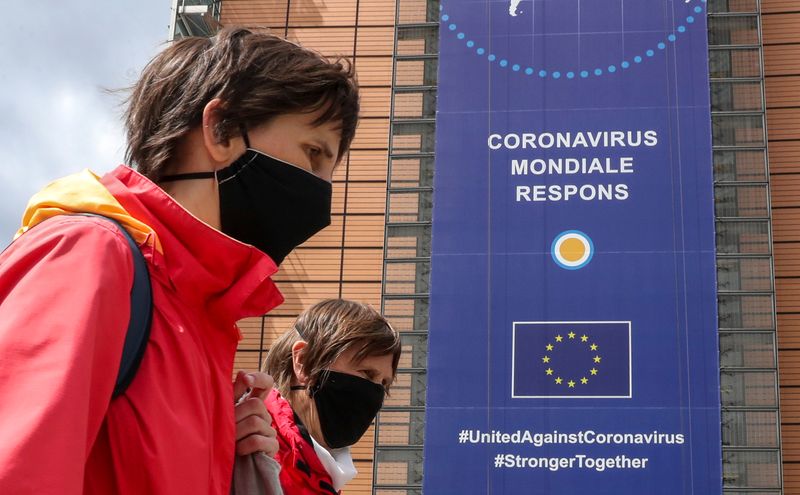 &copy; Reuters. Mulheres usando máscaras de proteção passam em frente à sede da Comissão Europeia em Bruxelas