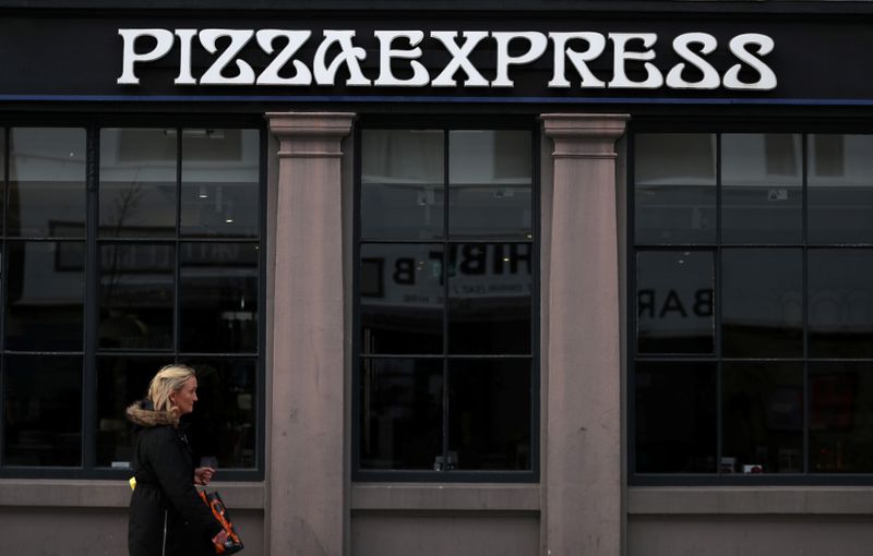 &copy; Reuters. A woman walks past a Pizza Express restaurant in London