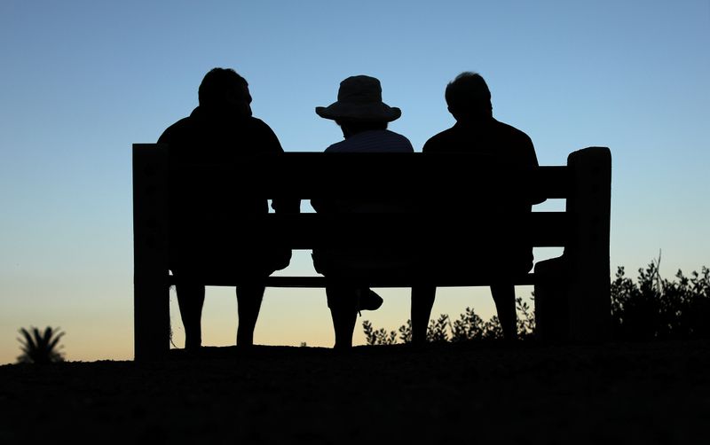 &copy; Reuters. FILE PHOTO: Elderly people sit on a park bench after sun set in Encinitas
