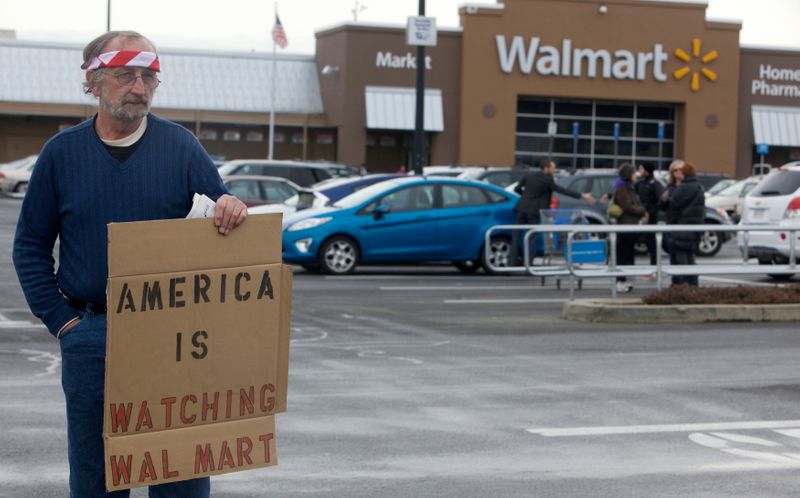 &copy; Reuters. FOTO DE ARCHIVO: Un hombre sostiene un cartel durante una protesta en la que los manifestantes pedían a Walmart que a detuviera la venta de armas de asalto y munición en todo el país, en Danbury, Estados Unidos