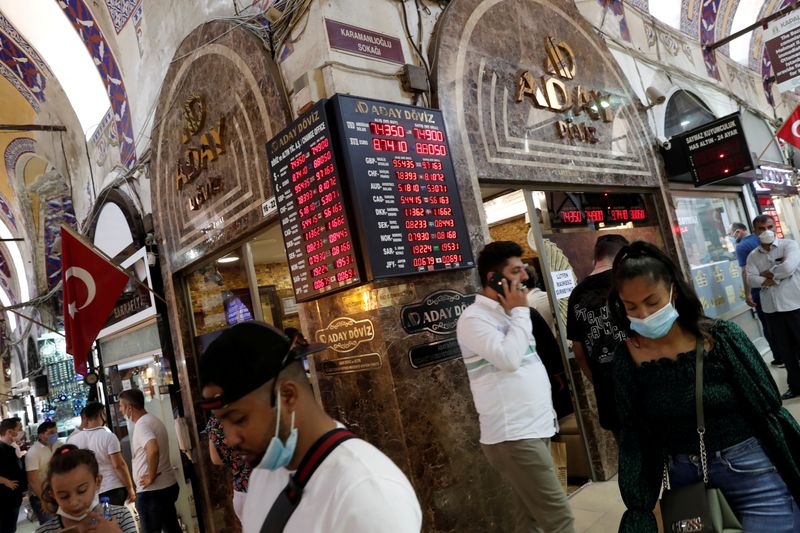 © Reuters. FILE PHOTO: People walk past by a currency exchange office at the Grand Bazaar in Istanbul