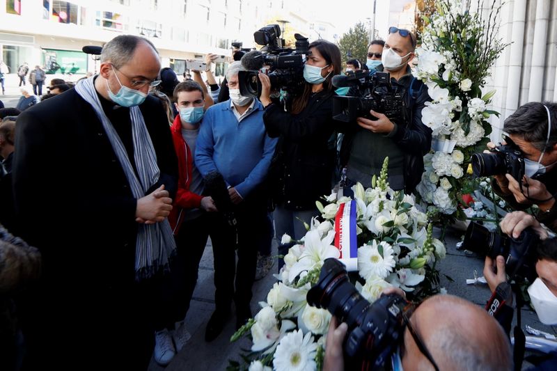 &copy; Reuters. Padre Franklin Parmentier é cercado por jornalitsas enquanto presta homenagem a vítimas de ataque em igreja de Notre Dame, em Nice, na França