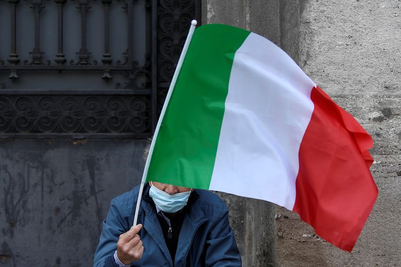 &copy; Reuters. Un uomo con in mano una bandiera italiana a Milano
