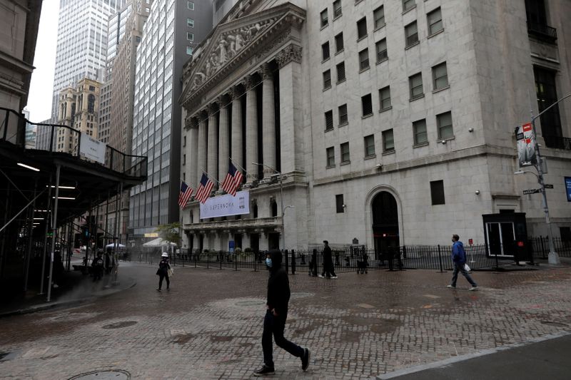 &copy; Reuters. People wearing protective face masks walk outside New York Stock Exchange in New York