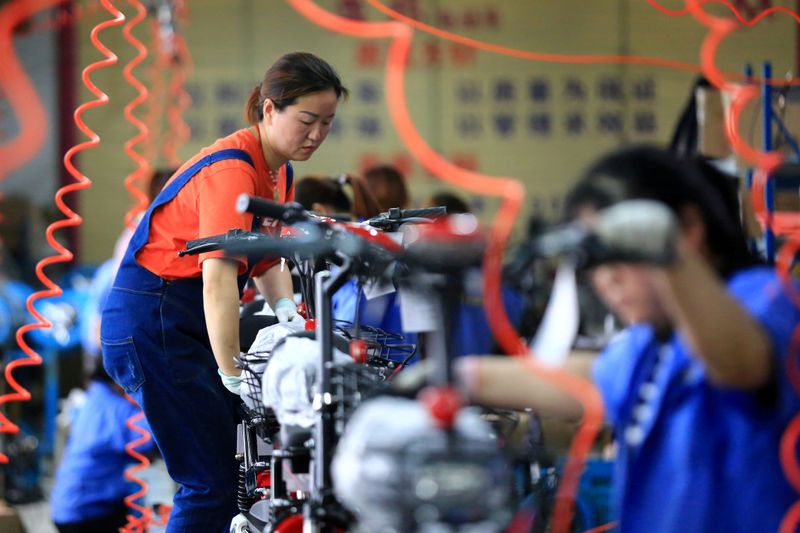 &copy; Reuters. FILE PHOTO: Woman work on manufacturing electric bicycles at a factory in Huaian, Jiangsu