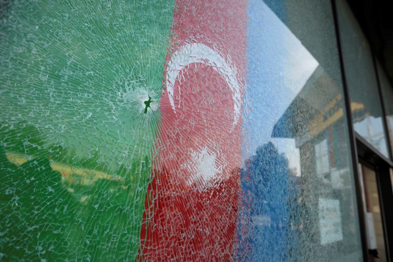 &copy; Reuters. A view shows an Azerbaijani flag behind a damaged window in Barda