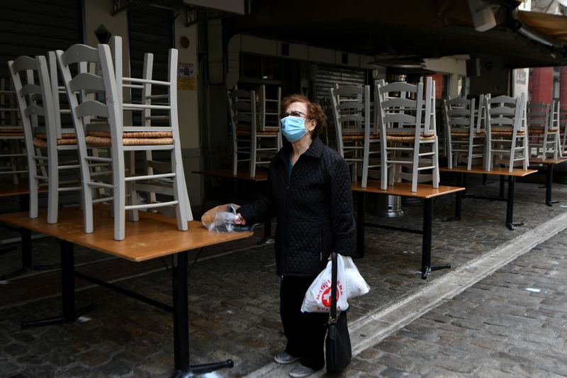 &copy; Reuters. A woman stands outside a closed restaurant, amid the coronavirus disease (COVID-19) pandemic, in Thessaloniki