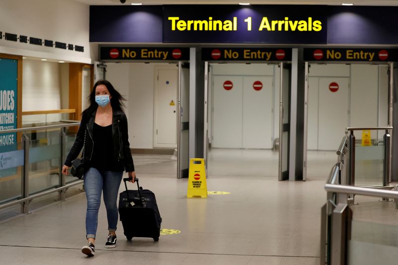 &copy; Reuters. FOTO DE ARCHIVO: Una pasajera con mascarilla pasa por la terminal de llegadas del aeropuerto de Manchester, en Manchester, Reino Unido, 8 de junio de 2020