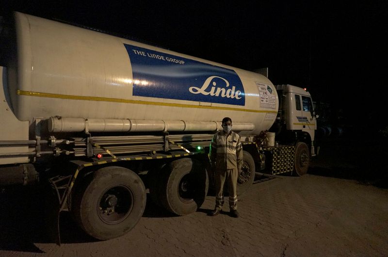 &copy; Reuters. Subhas Kumar Yadav poses in front of a tanker carrying liquid oxygen along a road in Selaqui