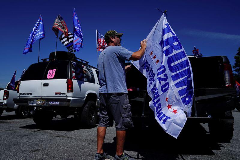 &copy; Reuters. FILE PHOTO: Man attaches a pro-Trump flag to a truck after participating in a caravan convoy in Adairsville