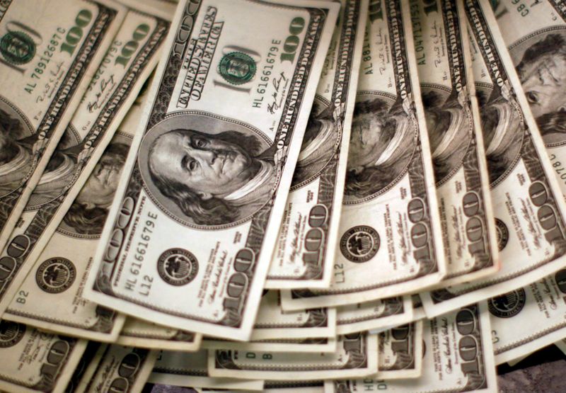 &copy; Reuters. FILE PHOTO: U.S. dollars are counted out by a banker at a bank in Westminster