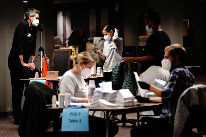 © Reuters. Trabajadores de las mesas electorales procesando los votos la noche del día de las elecciones en el Conteo Central de Milwaukee en Milwaukee, Wisconsin, EEUU