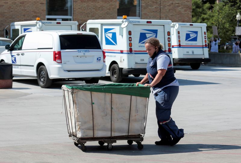 &copy; Reuters. FILE PHOTO: A United States Postal Service (USPS) worker pushes a mail bin outside a post office in Royal Oak