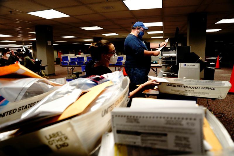 &copy; Reuters. Los trabajadores electorales Erin Keleske y Brett Rohlwing usan una máquina tabuladora para procesar los votos por correo en Milwaukee, Wisconsin, EEUU.