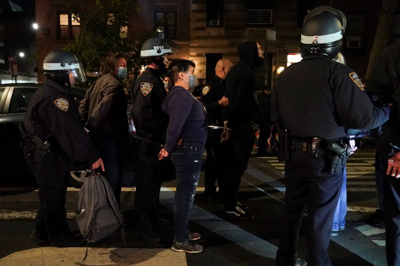 © Reuters. Police officers stand next to detained demonstrators near Washington Square park the day after Election Day in Manhattan, New York City