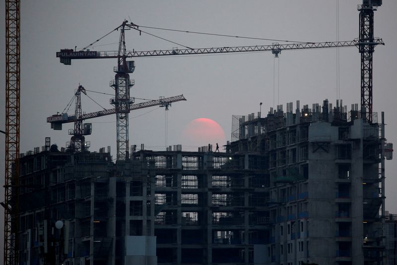 © Reuters. A worker walks at a construction site during dusk in Jakarta