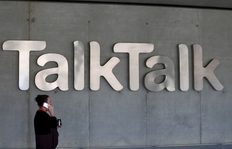 &copy; Reuters. FILE PHOTO: A woman speaks on her phone as she passes a branded logo outside the Talktalk headquarters in London