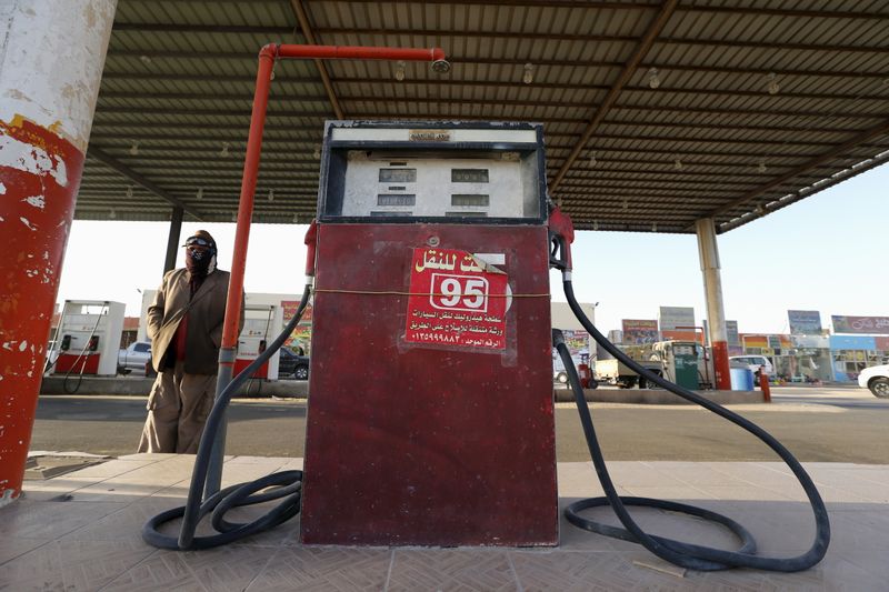 &copy; Reuters. A fuel pump assistant stands next to an old fuel pump during the early hours near the village of Salwa at the Qatari-Saudi border, south of the eastern provience of Khobar