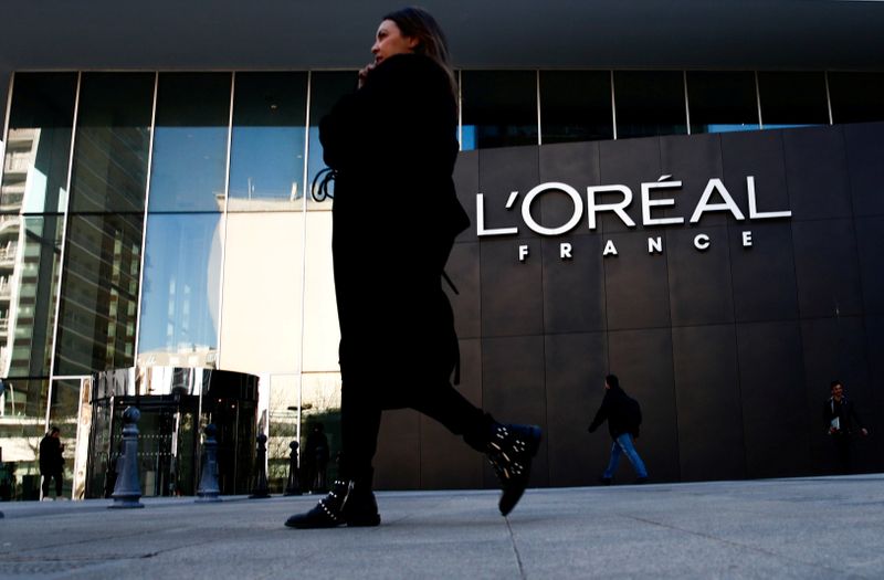 &copy; Reuters. FILE PHOTO: A woman walks by the logo of French cosmetics group L&apos;Oreal in the western Paris suburb of Levallois-Perret