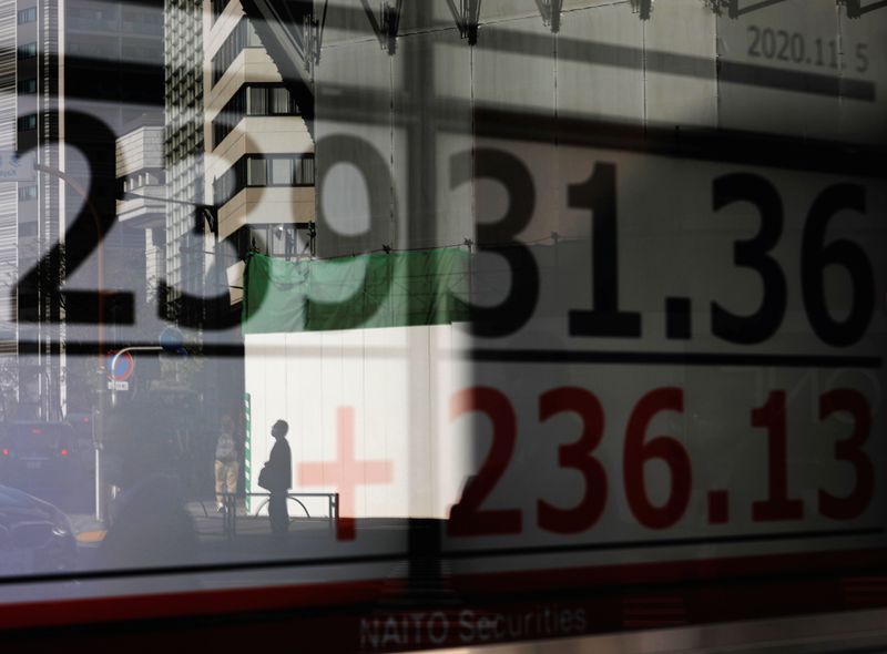 &copy; Reuters. A man is reflected on a screen showing Nikkei index outside a brokerage in Tokyo