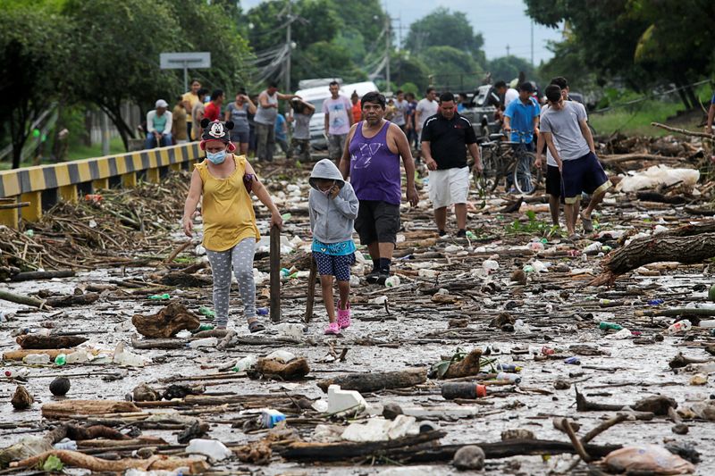 &copy; Reuters. Pessoas caminham em meio a destrços deixados por tempestade Eta em Pimenta, Honduras