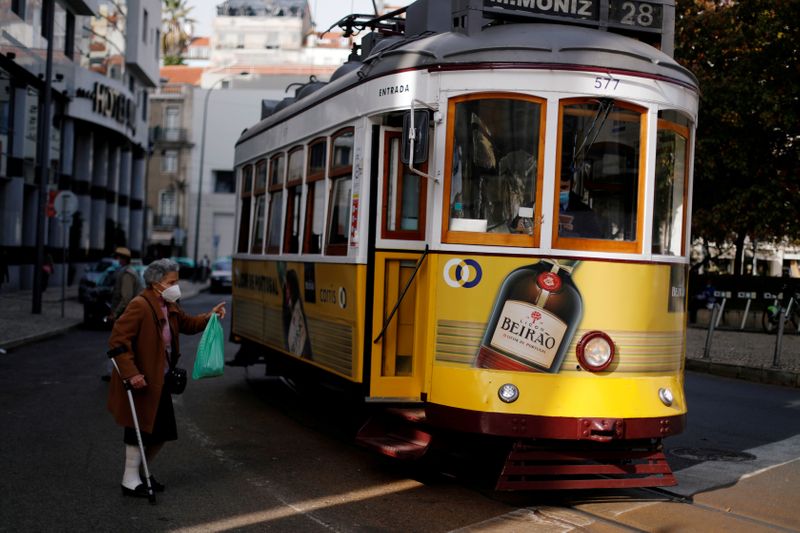 &copy; Reuters. Mulher usando máscara de proteção conversa com motorista de bonde em Lisboa