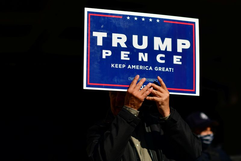 © Reuters. A Trump supporter clutches a campaign sign with both hands after Democratic presidential nominee Joe Biden overtook President Donald Trump in Philadelphia