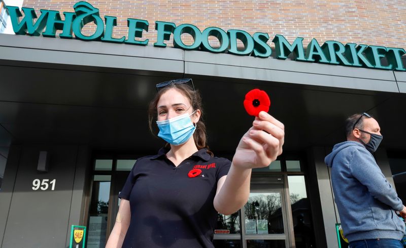 © Reuters. Sara Stresman, a server at the nearby Sunset Grill, poses with a poppy in front of a Whole Foods store in Ottawa