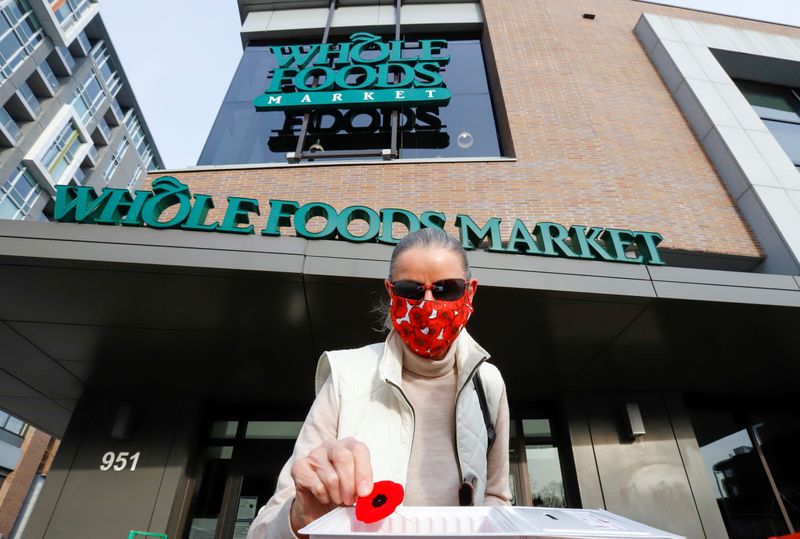 &copy; Reuters. Dagmar Dohler takes a poppy that is given away in front of a Whole Foods store in Ottawa