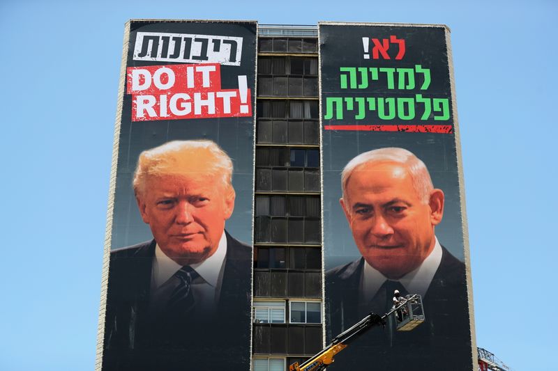 &copy; Reuters. FILE PHOTO: A labourer puts up banners depicting U.S. President Donald Trump and Israeli Prime Minister Benjamin Netanyahu, part of a new campaign by the umbrella Yesha Jewish settler council in Jerusalem