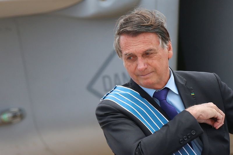 &copy; Reuters. FILE PHOTO: Brazil&apos;s President Jair Bolsonaro looks on in front of a Brazilian Air Force F-39E Gripen fighter during a ceremony of Aviator&apos;s Day at Brasilia Air Base